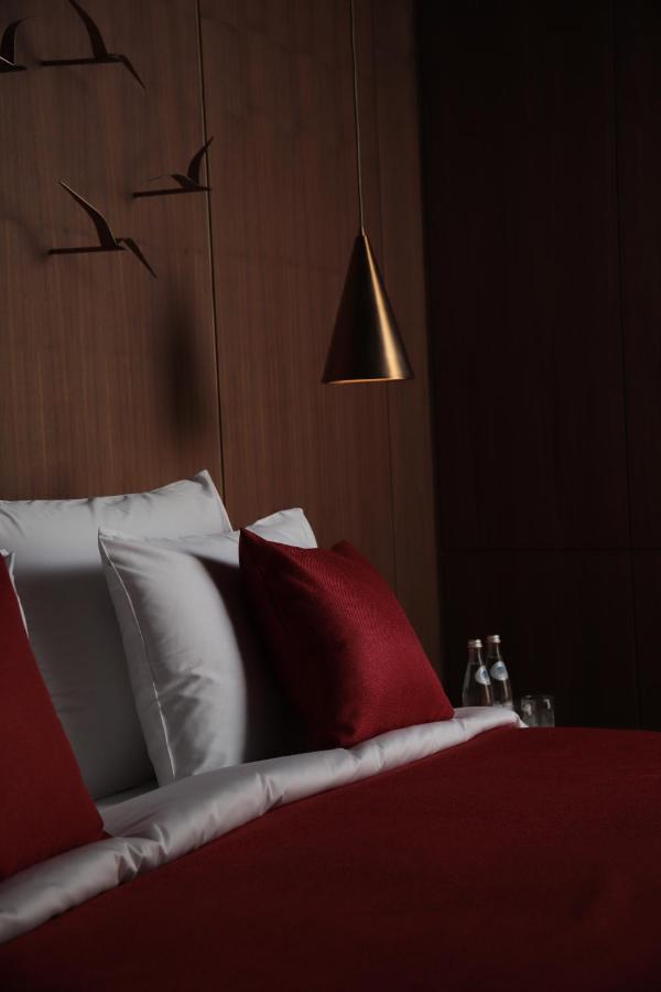 The Veil Hotel Астана Экстерьер фото A bed with a red pillow